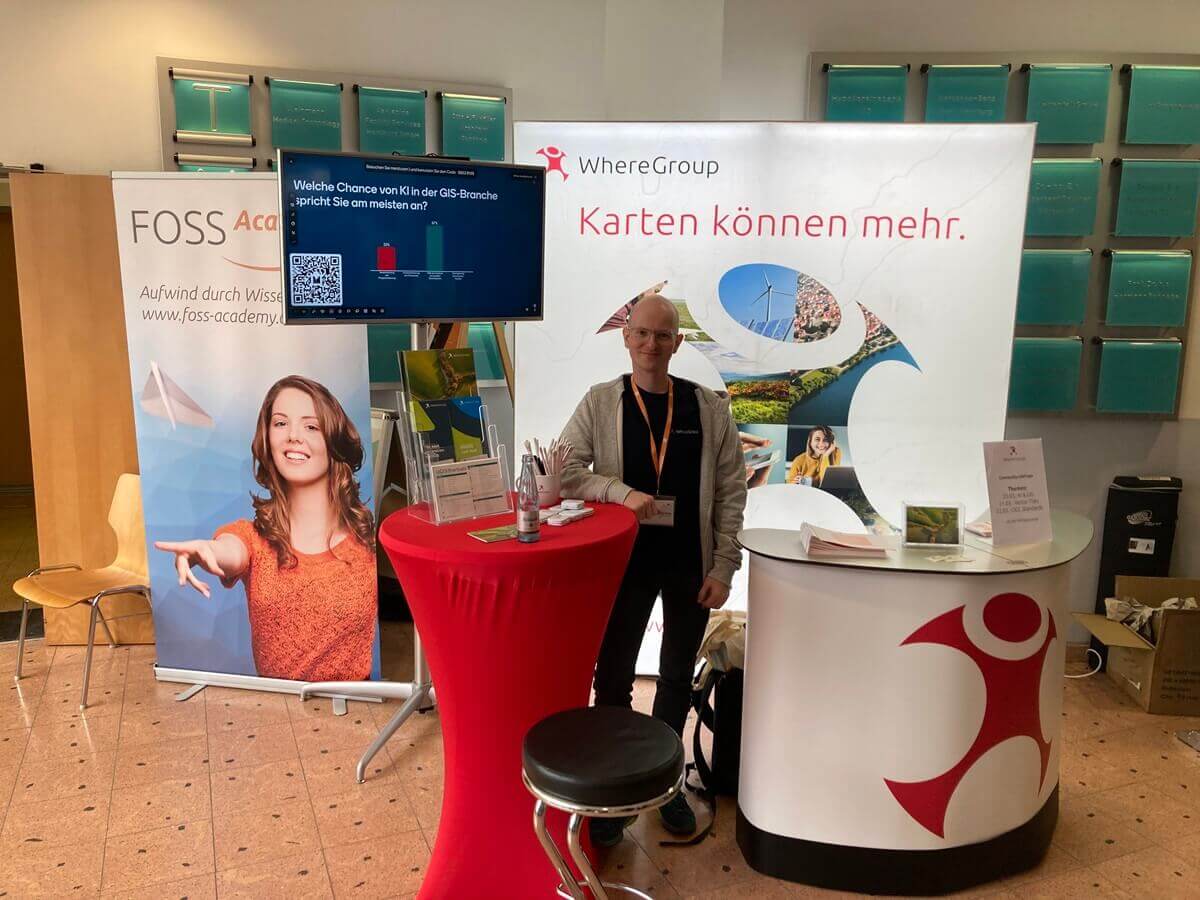 Mann vor einem Messestand auf der FOSSGIS
